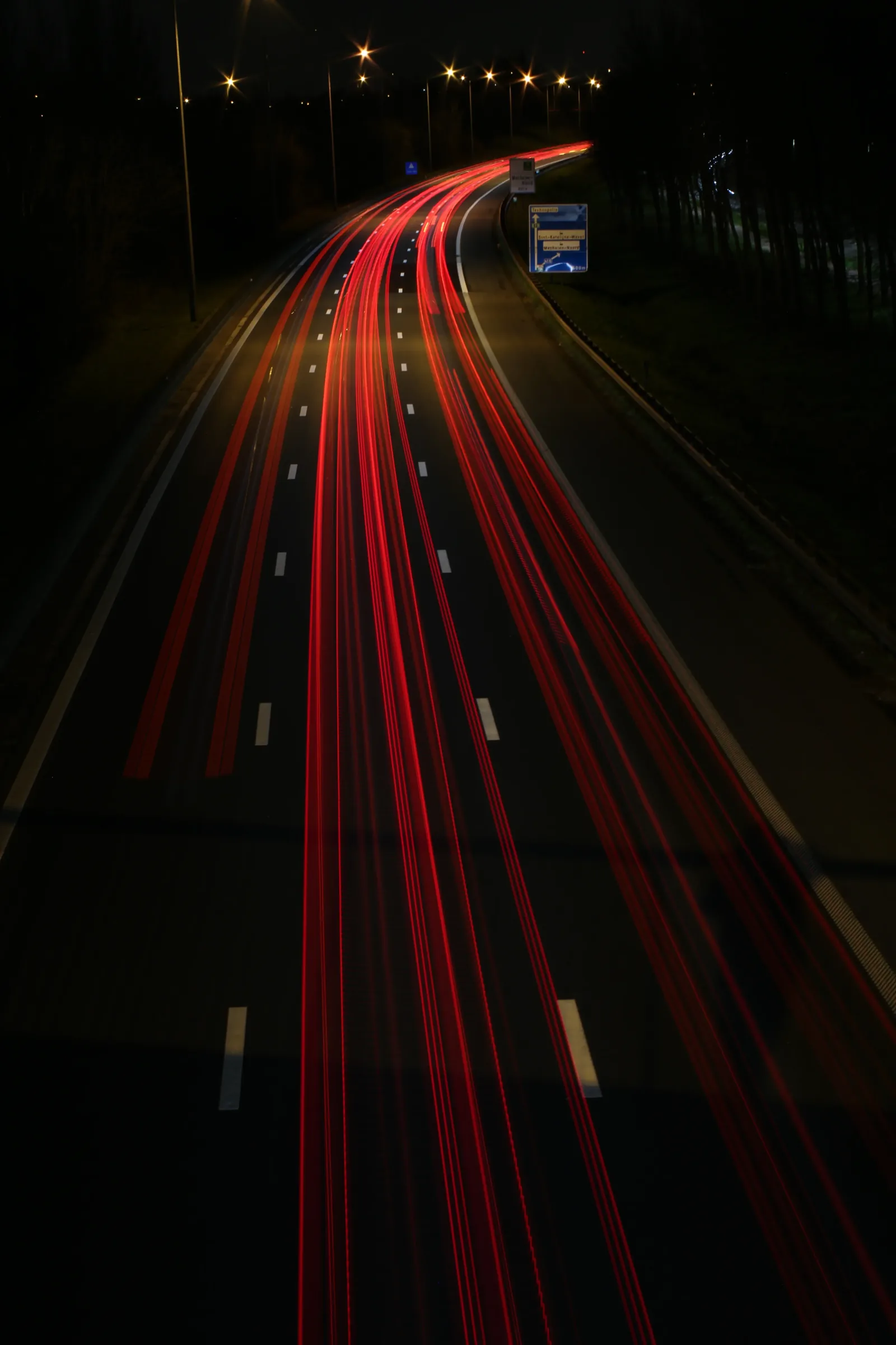 Long exposure red light trails shot from a bridge at night